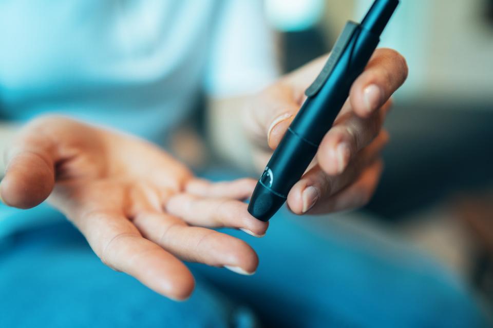 Woman doing her diabetes blood test at home