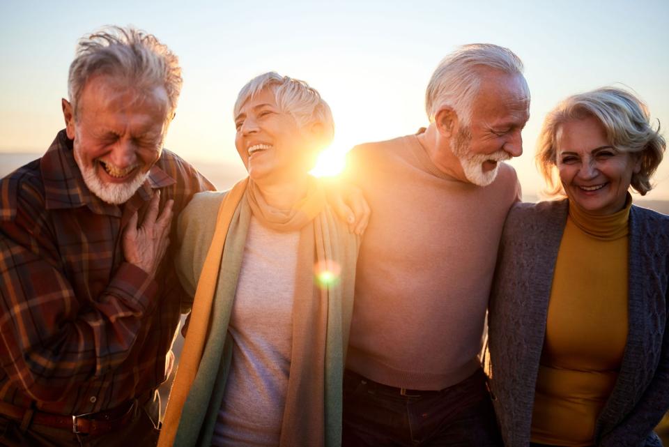 Quatre personnes âgées riant en plein air