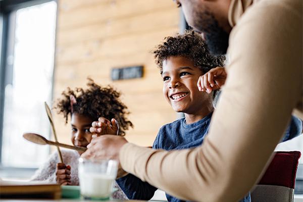 Young boy laughing eating breakfast