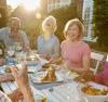 Group de gens plus agés qui mangent autour d`une table dehors