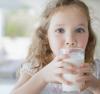 Petite fille buvant un verre de lait